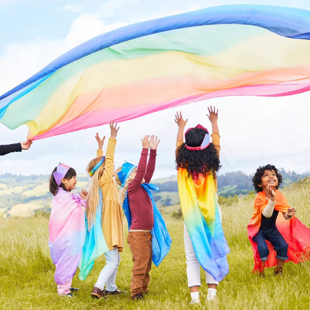 Children outside in garden hands up looking upwards over them a colorful canopy sarasilk